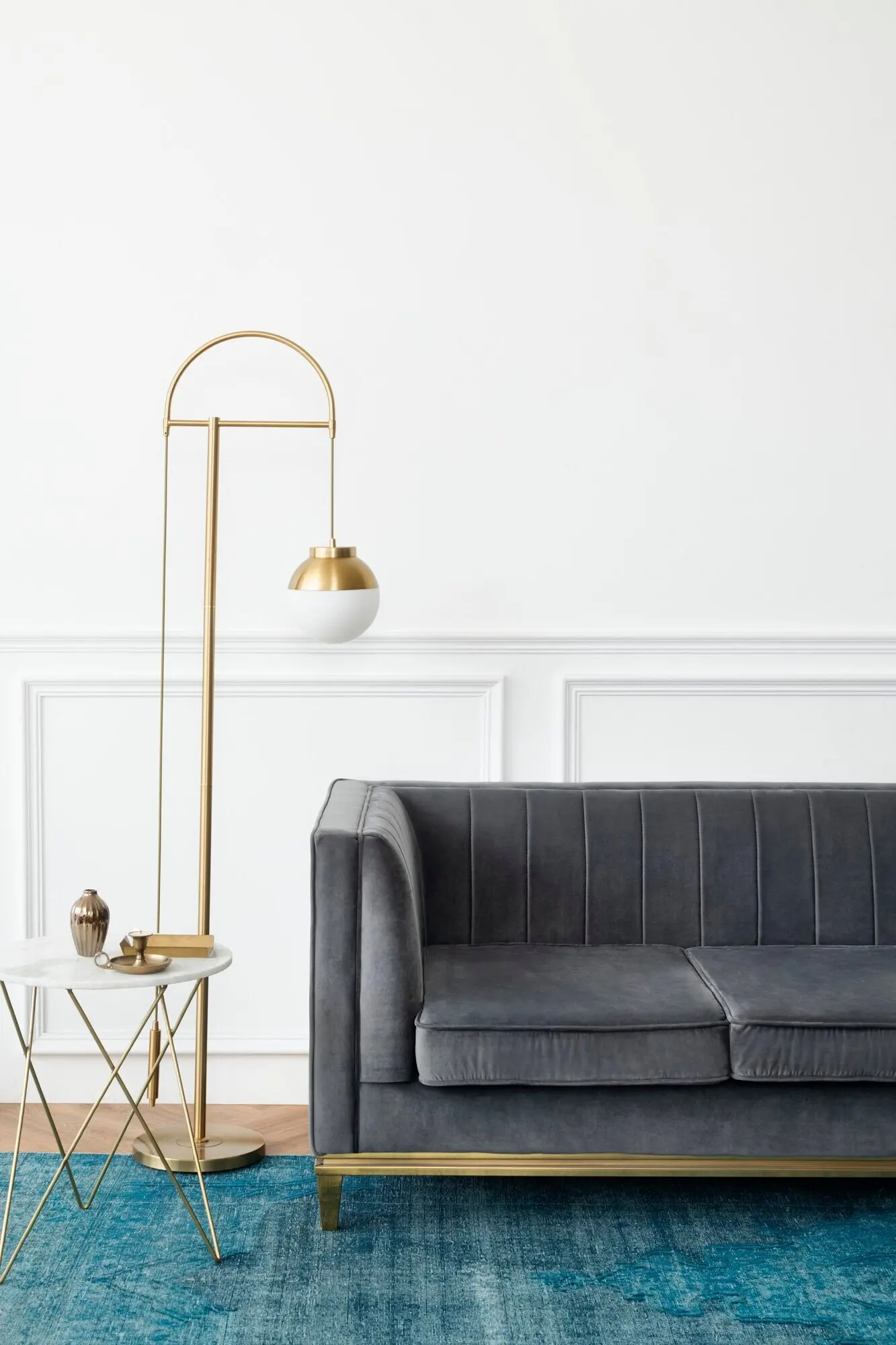 Schickes Wohnzimmer im luxuriösen Mid-Century-Modern-Stil mit grauem Samtsofa und blauem Teppich.